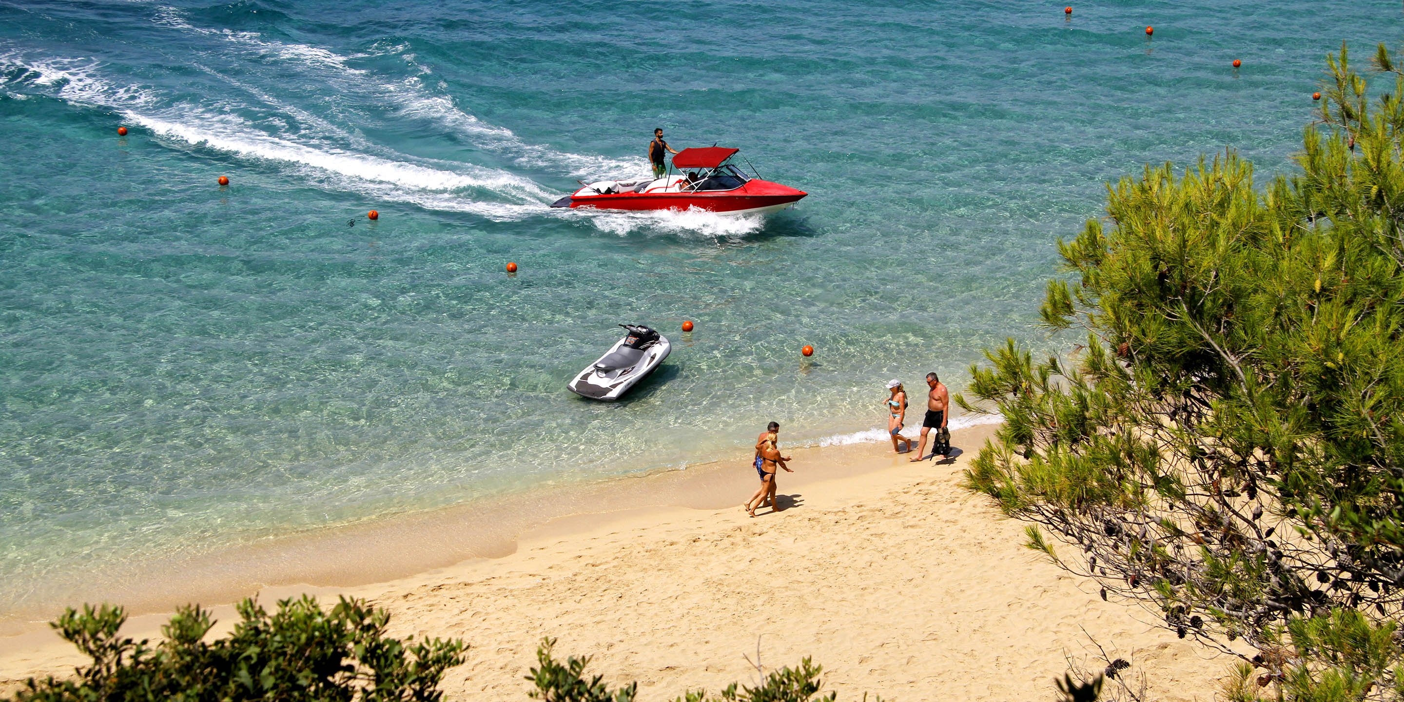 People enjoying an walk on the sand at Makris Gialos Beach