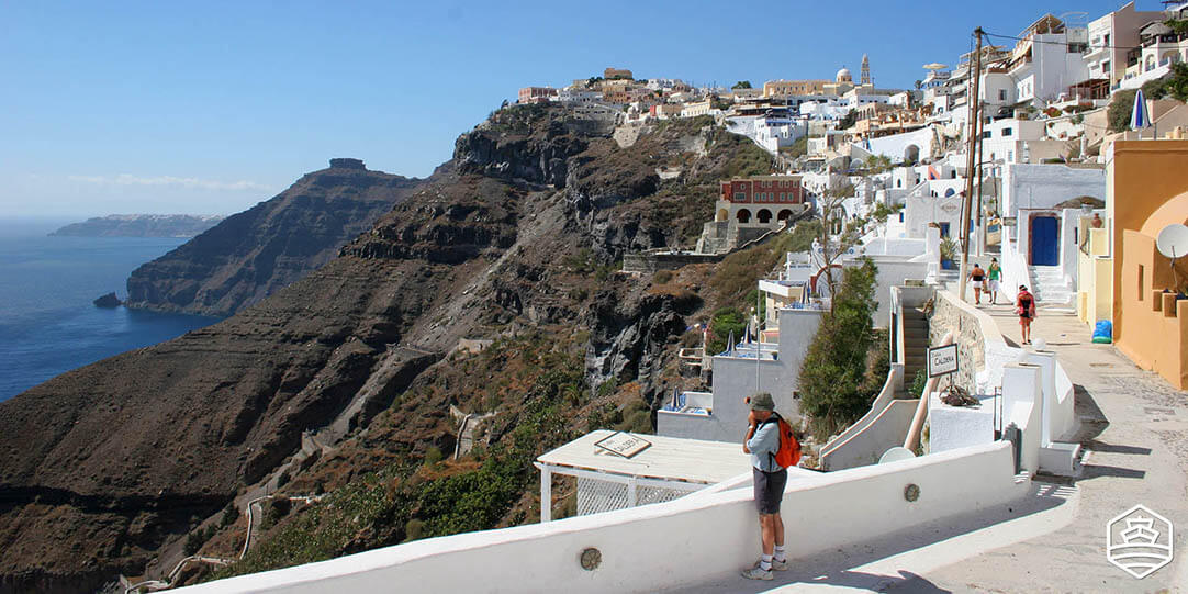 Photographe capturant la vue depuis le village de Fira à Santorin